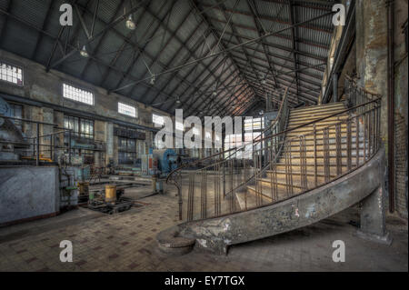 Imposing staircase inside the hall of an abandoned power plant Stock Photo