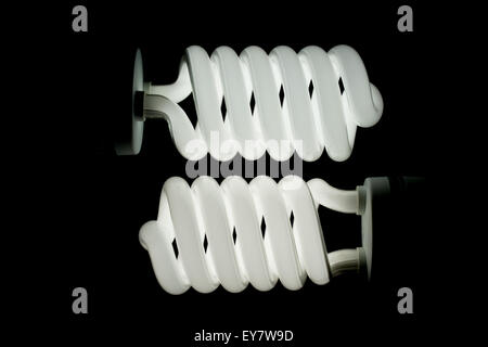 Two low energy spiral light bulbs illuminated Stock Photo