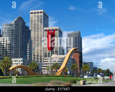 Cupid's Span a giant bow and arrow sculpture on the Embarcadero with Embarcadero Centre and Financial District behind San Francisco California USA Stock Photo