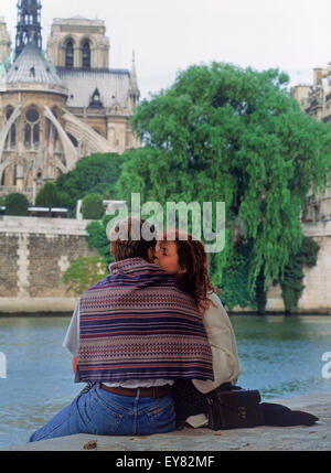 Couple kissing at Ile St Louis on River Seine across from Notre Dame in Paris Stock Photo