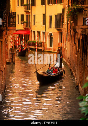 Gondolas filled with tourists passing on narrow canals in Venice Stock Photo