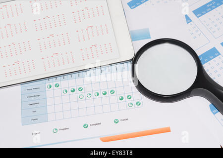 Project schedule with magnifier and calendar on the tablet screen Stock Photo
