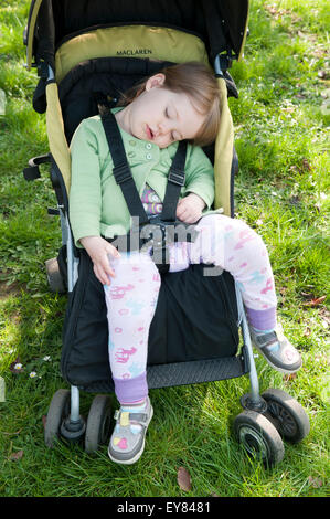 Toddler asleep in her pushchair Stock Photo