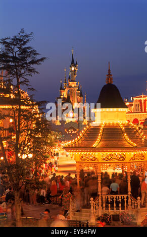 The Castle with Main Street shops and people in twilight light at Euro Disney Resort outside Paris Stock Photo