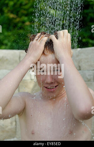 Boy having a shower, outdoors, summer refreshment Stock Photo