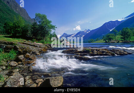 Woman resting next to Rauma River in Møre-Romsdal region of Norway Stock Photo