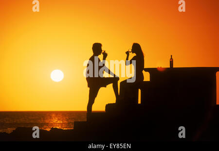 Couple enjoying a glass of wine at sunset along coast of Uruguay Stock Photo