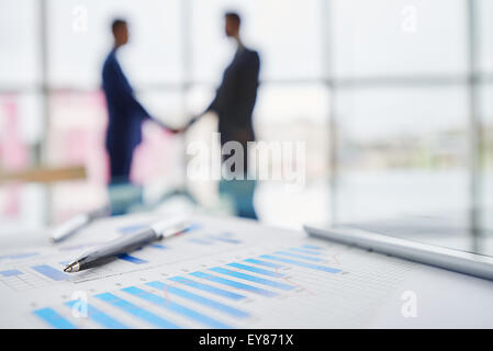 Pen and document with chart on background of office workers Stock Photo
