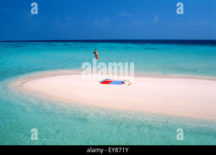 Couple playfully embracing near sandbar in Maldive Islands on Maayafushi Island in North East Ari Atoll Stock Photo