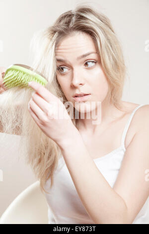 Blond, young woman brushing her long hair Stock Photo - Alamy