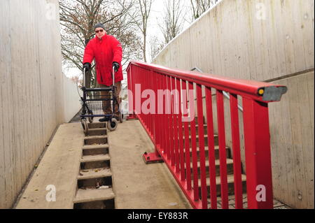 Worms, Germany - December 1, 2010: Old man having difficulties to move barrier-free though his city Stock Photo
