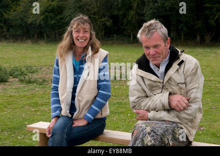 Man and women sitting together on a bench smiling Stock Photo