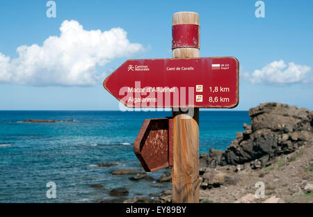 A weathered red metal sign post points the route on the Cami de Cavalls bridal trail on the island of Mneorca Spain Stock Photo