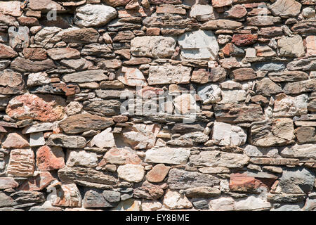 Old wall made of irregular shaped stones Stock Photo