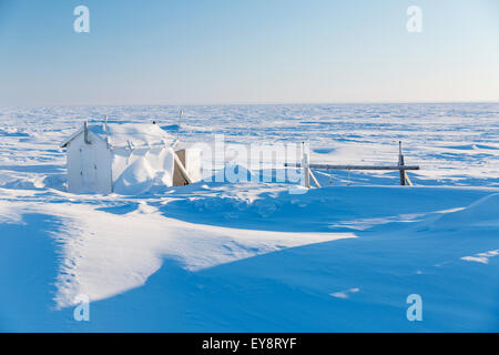 Snow Drifts cover summer camps buildings at point Barrow, Arctic Alaska, in winter; Barrow, Alaska, United States of America Stock Photo