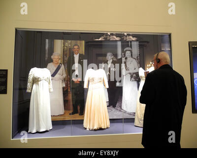 London, UK. 24th July, 2015. A visitor looks at some of the Queen's dresses, on display at Buckingham Palace pictured at 'A Royal Welcome' in London, UK, 24 July 2015. Buckingham Palace opens its doors to the public from 25 July - 27 September 2015. Photo: Teresa Dapp/dpa/Alamy Live News Stock Photo