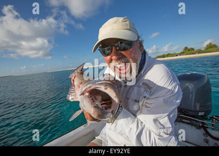 Fisherman holding a fresh caught Grouper; Tahiti Stock Photo