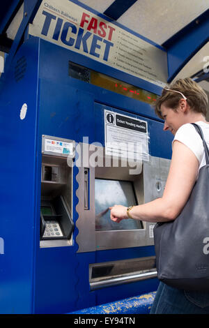 A young woman using a Fast Ticket machine at Warwick train station ...