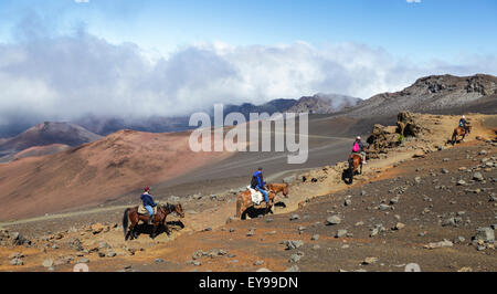 Horseback riders on Pony Express tour ride up the Sliding Sands Trail at Haleakala National Park on Maui Stock Photo