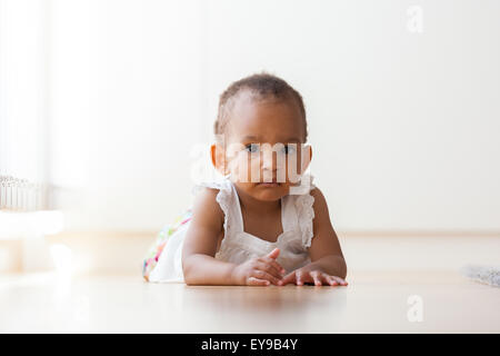 Portrait of little African American little girl lying down on the floor  - Black people Stock Photo