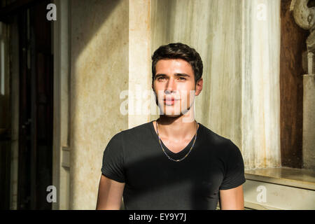 Head and shoulder shot of handsome attractive young man looking up, indoor, lit by sunlight Stock Photo