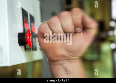 Male hand pushing emergency red stop button. Stock Photo