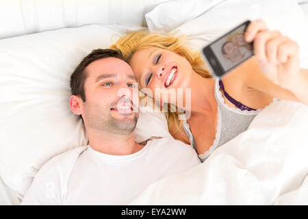 View of a Young attracttive couple taking selfies in bed Stock Photo