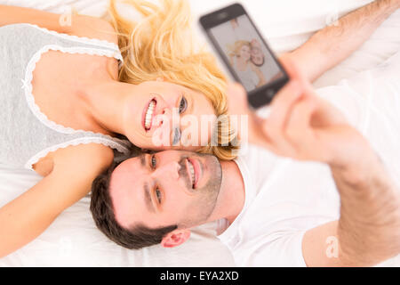 View of a Young attracttive couple taking selfies in bed Stock Photo