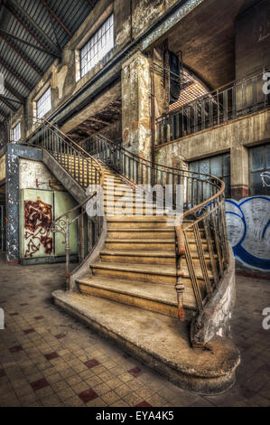 Imposing staircase inside the hall of an abandoned power plant Stock Photo