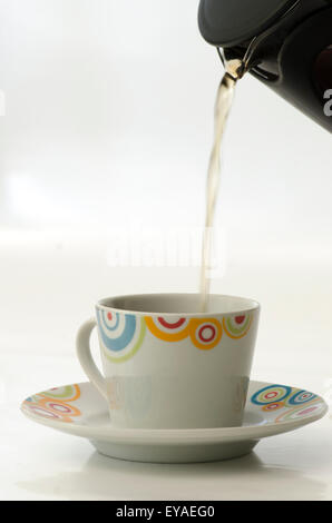 Tea pouring in cup from french press isolated on white background Stock Photo