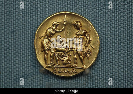 Roman golden stater. Extremely rare Roman republican golden coin issued after the First Punic War from 225-212 BC. Kunsthistorisches Museum, Vienna, Austria. Oath scene with two warriors, one Roman and the other representing the Italian allies, standing facing each other, holding spears and touching with their swords a sacrificial pig held by a figure kneeling between them. The meaning of this scene is clear: Rome demonstrates to her allies that the war against Carthage is a cooperative effort. This was the first Roman coin in gold. Stock Photo