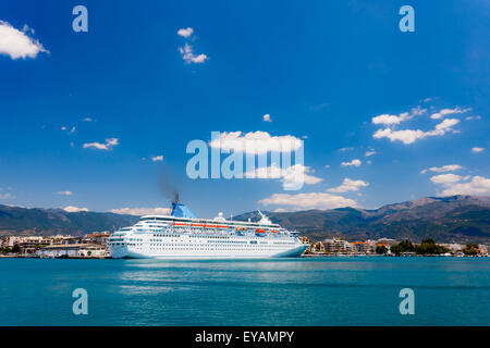 Big cruise ship anchored in port against a blue sky and clouds in Greece Stock Photo