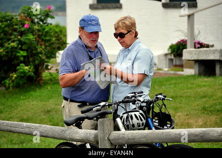 Jamestown, Rhode Island:  Man and woman with their parked bicycles studying a road map at 1856 Beavertail State Park Lighthouse Stock Photo