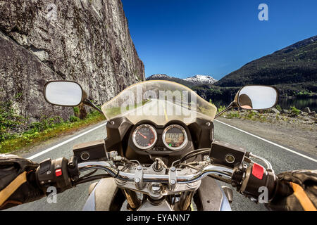 Biker rides a motorcycle on mountain serpentine. First-person view. Stock Photo