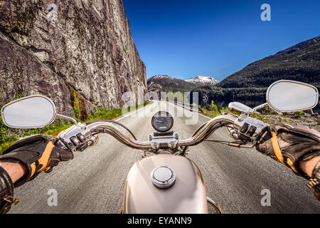 Biker rides a motorcycle on mountain serpentine. First-person view. Stock Photo