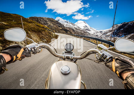 Biker rides a motorcycle on mountain serpentine. First-person view. Stock Photo