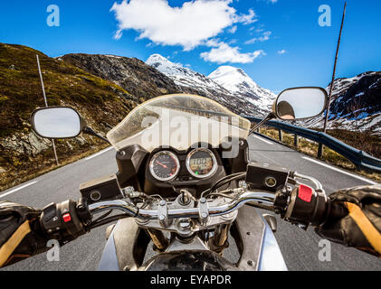 Biker rides a motorcycle on mountain serpentine. First-person view. Stock Photo