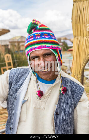 Floating Islands, Lake Titicaca, Puno, Peru. Smiling friendly boatman on Isla Apu Inti island wearing a colourful knitted cap Stock Photo