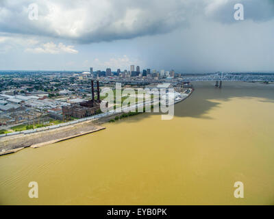 The dirty Mississippi River flowing through New Orleans with an ominous, dark cloud in the background. Stock Photo