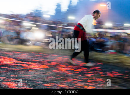 Rozhen, Bulgaria - July 18, 2015: A nestinar is walking on fire during a nestinarstvo show. The fire ritual involves a barefoot  Stock Photo