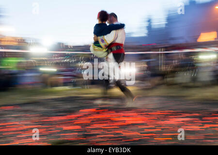 Rozhen, Bulgaria - July 18, 2015: A nestinar with a child is walking on fire during a nestinarstvo show. The fire ritual involve Stock Photo