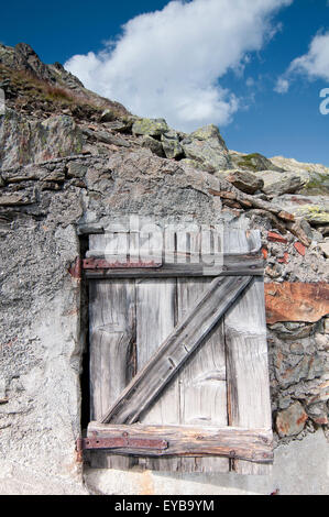 Wooden door in a stone shepherd's hut in Great Saint Bernard Pass. Swiss Alps. Switzerland. Stock Photo