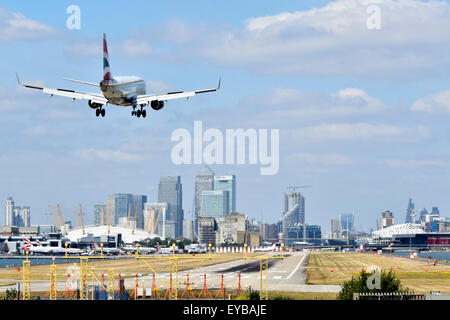 British Airways plane landing London City Airport Newham with O2 arena & Canary Wharf in London Docklands skyline beyond in Tower Hamlets England UK Stock Photo