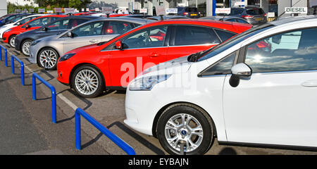 Ford car dealership business edge of pavement forecourt display of row of second hand used cars for sale dealer name removed Essex England UK