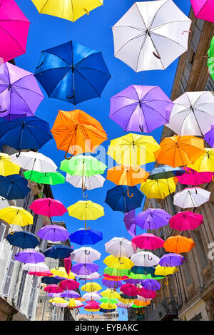 Blue sky & parasol umbrella colours in street art display in the ancient French City of Arles France Provence Stock Photo