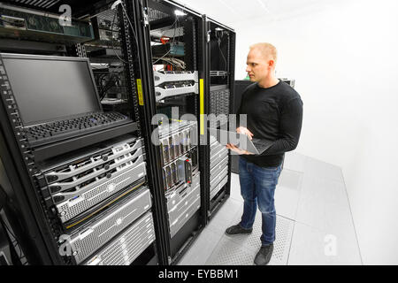 It engineer maintains servers in datacenter Stock Photo
