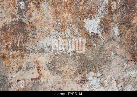 Abstract background of old painted plastered wall with peeling paint texture in brown, grey, and orange colors Stock Photo