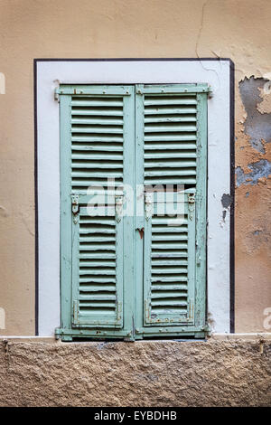 Old french windows with blue closed shutters in Villefranche-sur-Mer, France. Stock Photo