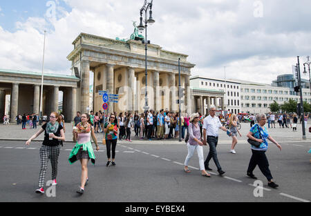 Berlin, Germany. 25th July, 2015. Pedestrians cross a street in front of the Brandenburg gate in Berlin, Germany, 25 July 2015. Photo: Lukas Schulze/dpa/Alamy Live News Stock Photo