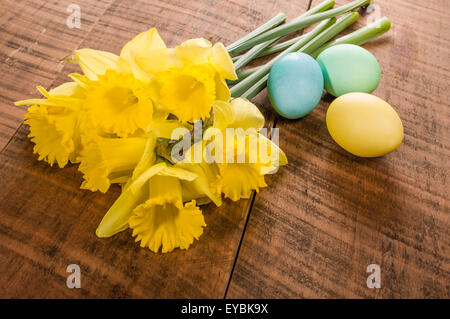 Yellow daffodils and colorful dyed Easter eggs Stock Photo